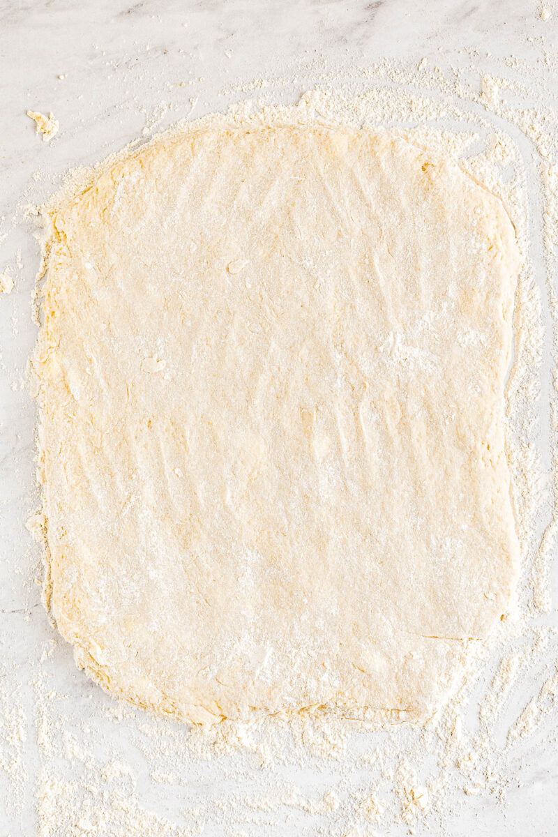 A rectangle of angel biscuit dough on a floured surface.