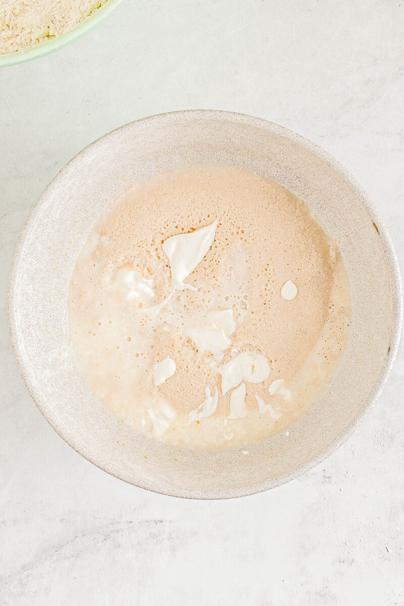 Wet ingredients for angel biscuits being whisked in a bowl.