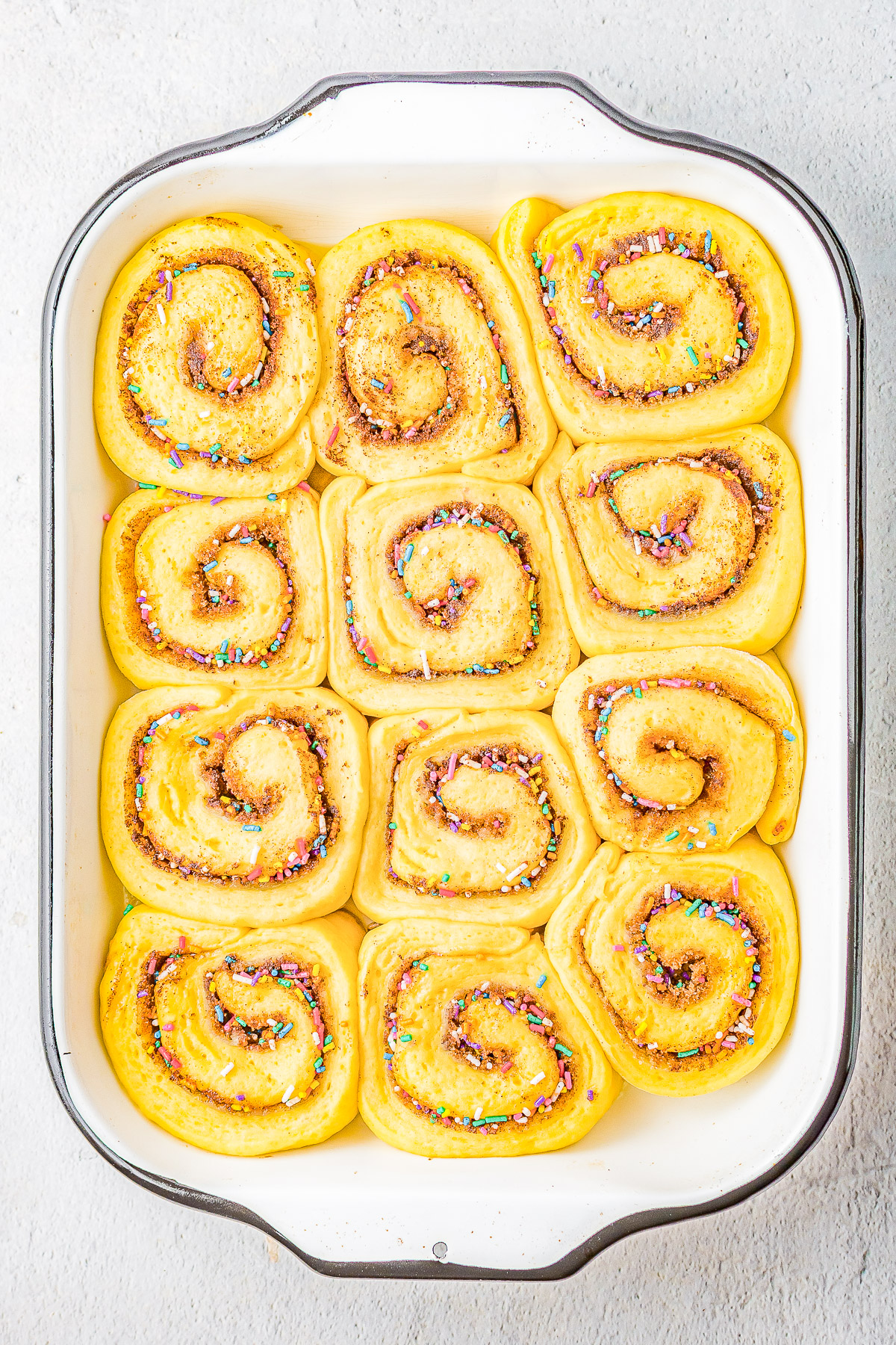 Birthday Cake Cinnamon Rolls - The softest, fluffiest, most tender cinnamon rolls stuffed with cinnamon-and-sugar and rainbow sprinkles! Topped with tangy cream cheese frosting and more sprinkles! The recipe is EASY to follow even if you've never made cinnamon rolls and there's a MAKE AHEAD overnight option!