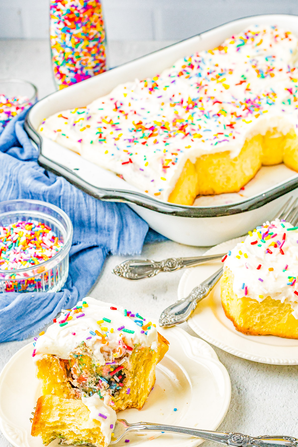 Birthday Cake Cinnamon Rolls - The softest, fluffiest, most tender cinnamon rolls stuffed with cinnamon-and-sugar and rainbow sprinkles! Topped with tangy cream cheese frosting and more sprinkles! The recipe is EASY to follow even if you've never made cinnamon rolls and there's a MAKE AHEAD overnight option!