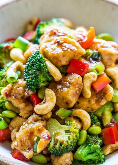 A bowl of stir-fried chicken with broccoli, cashews, red peppers, and carrots.