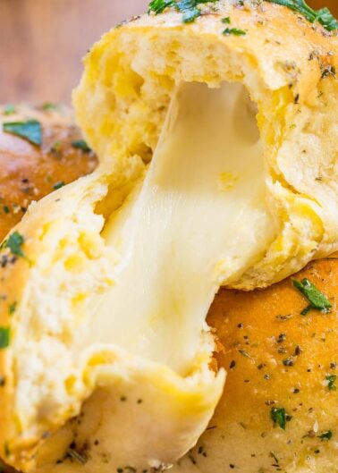 Freshly baked garlic bread roll with melting cheese center.