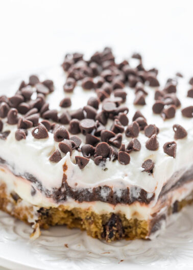 A slice of chocolate chip cookie dough lasagna on a white plate.