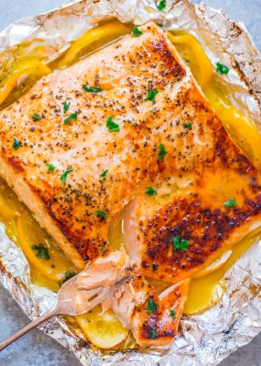 Grilled salmon fillet in foil with lemon and herbs.