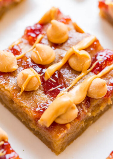 A close-up of a peanut butter and jelly bar with a drizzle of caramel.
