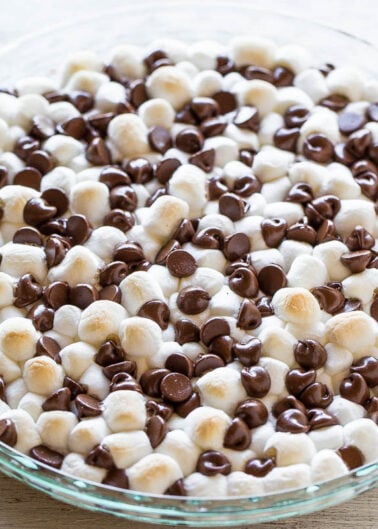 A glass dish filled with alternating layers of chocolate chips and miniature marshmallows.