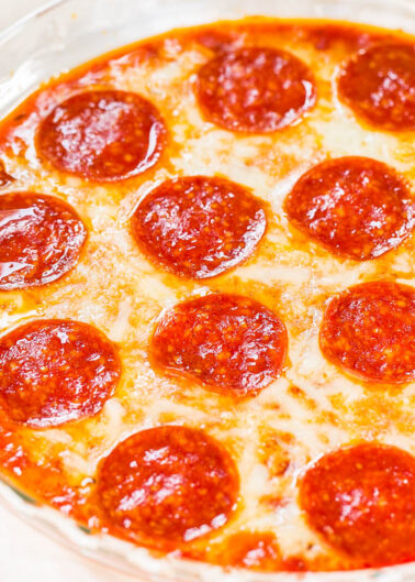 A close-up of a pepperoni pizza with melted cheese in a glass dish.