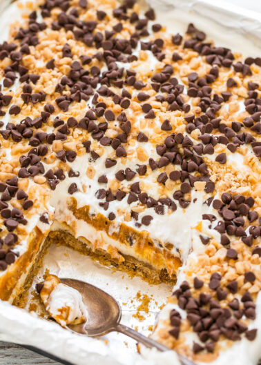 A baking sheet with a half-eaten dessert bar topped with marshmallow and chocolate chips.