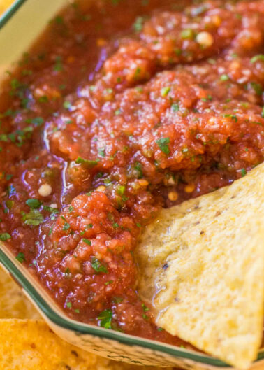 A bowl of chunky salsa with tortilla chips.