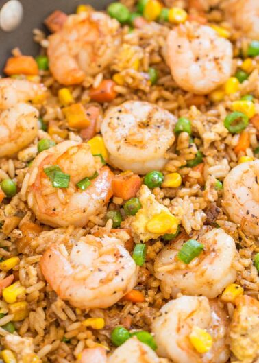 Shrimp fried rice with assorted vegetables in a pan.