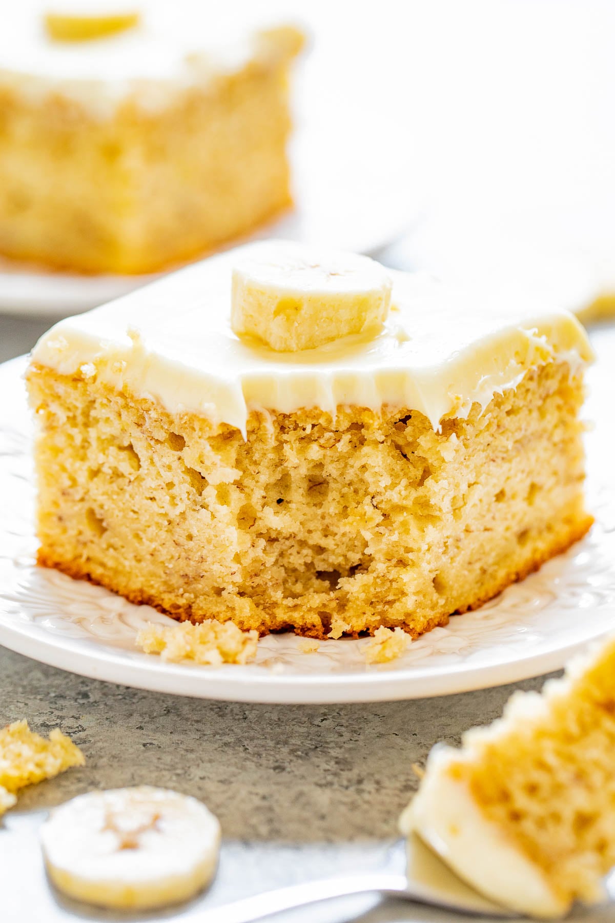 Best Banana Cake with Cream Cheese Frosting, a corner bite missing. 