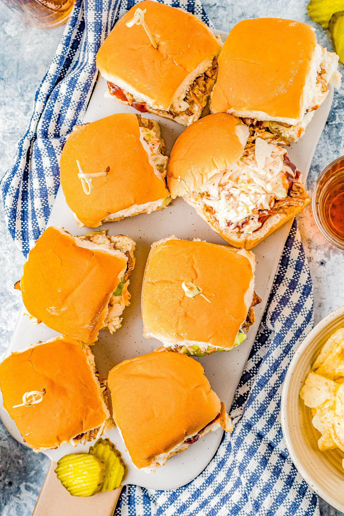 Easy Pulled Pork Sliders - Moist and tender pulled pork, topped with barbecue sauce and coleslaw, and sandwiched between soft Hawaiian rolls! Everyone LOVES these EASY juicy sliders that are finger lickin' good! PERFECT for game days, casual entertaining, backyard barbecues, graduation and Father's Day celebrations.