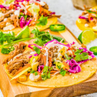 Pulled pork tacos with cilantro lime slaw, pickled red onions, and avocado crema.