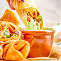 Southwestern Egg Rolls - Juicy chicken, melted Pepper Jack cheese, black beans, bell peppers, and corn seasoned with southwest-inspired seasonings and fried to crispy PERFECTION! You can fry, air fry, or bake these EASY egg rolls which are a Chili's Restaurant copycat. The quick creamy mashed avocado ranch dipping sauce is the perfect final touch!