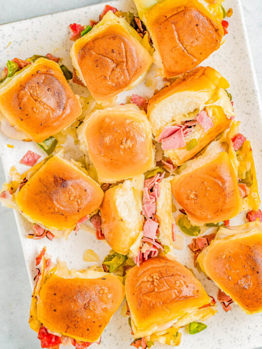 Roast Beef Sliders - Tender roast beef is mixed with sauteed green peppers and onions, piled into soft Hawaiian rolls, topped with Provolone cheese, and brushed with butter and garlic before baking! These juicy sliders are fast, EASY, and perfect for Father's Day, backyard barbecues, potlucks, game day events, or anytime you need a great comfort food recipe!