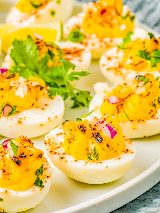 Mexican Street Corn Deviled Eggs - Deviled eggs get a south-of-the-border makeover by incorporating grilled Mexican street corn, jalapeno, red onion, cilantro, lime juice, queso fresco, and chili powder! This is an EASY appetizer or picnic recipe that everyone adores! Serve these at your next summer event including Memorial Day, Father's Day, Fourth of July, or make them for game day parties!