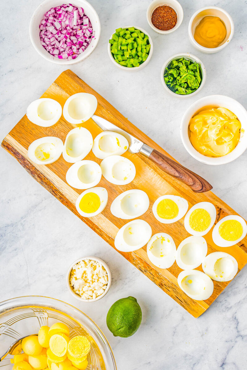 Hard boiled eggs split on a cutting board.
