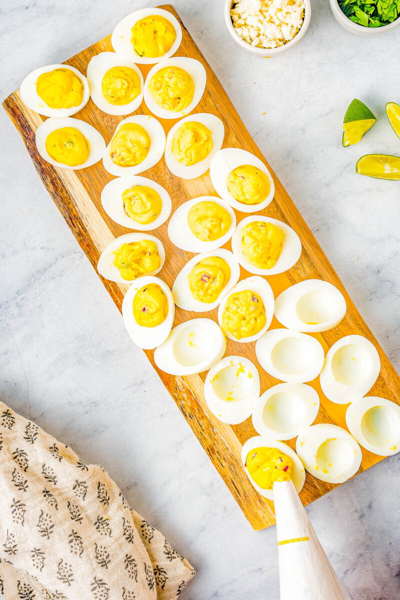 Mexican Street Corn Deviled Eggs being filled with a piping bag.
