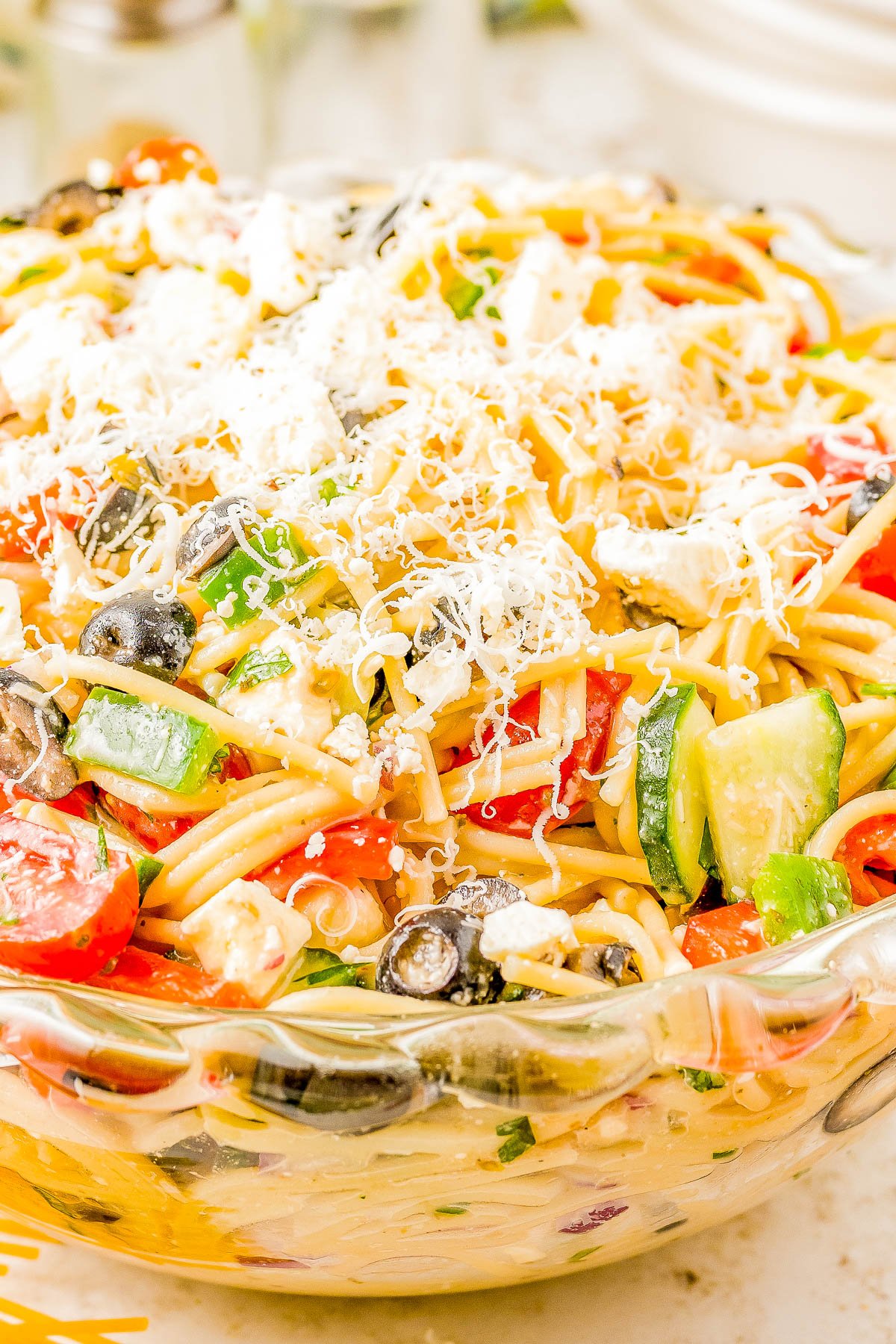 Spaghetti Pasta Salad - If you need a FAST and EASY hit for your next potluck, summer picnic, or barbeque, look no further than this spaghetti pasta salad recipe! Served chilled, it’s full of juicy cherry tomatoes, cucumbers, bell peppers, salty olives, plenty of Parmesan and feta cheese, and coated with tangy Italian dressing so it's bursting with FLAVOR!