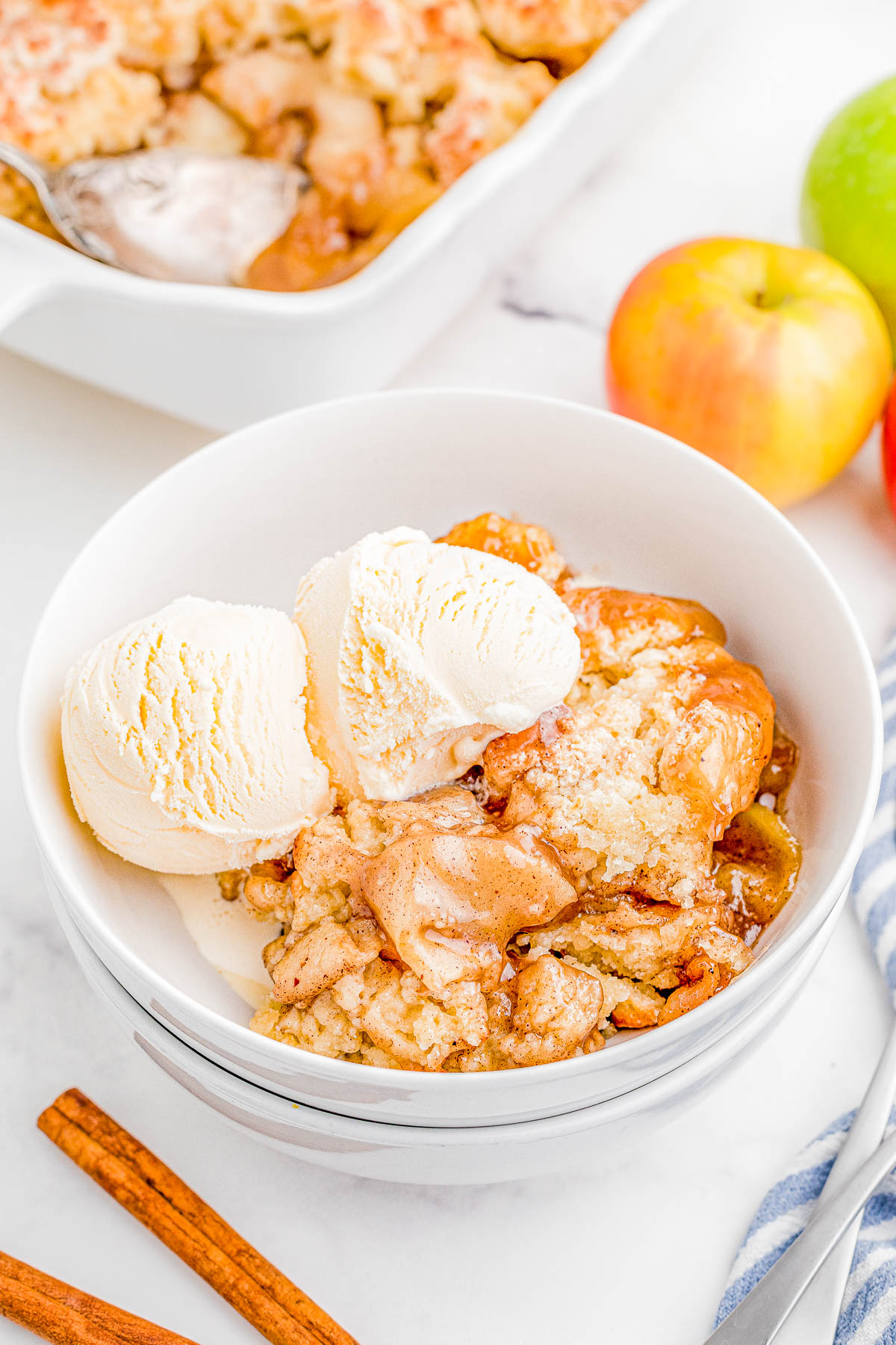 Easy Apple Cobbler — A spiced apple filling is topped with a sweet biscuit topping before being baked to golden brown and bubbly perfection! Apple cobbler is such an EASY dessert to make and tastes even better when drizzled with caramel sauce and served with a scoop of ice cream! 