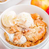 Easy Apple Cobbler in a bowl topped with vanilla ice cream.