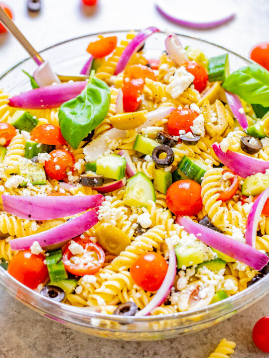 Mediterranean Pasta Salad - Juicy tomatoes and cucumbers, black and green olives, crumbled feta, and tender pasta are tossed in a homemade balsamic vinaigrette! An EASY pasta salad recipe with Mediterranean-inspired ingredients that's ready in under 30 minutes! It makes a big batch and is perfect for potlucks, picnics, or planned leftovers.