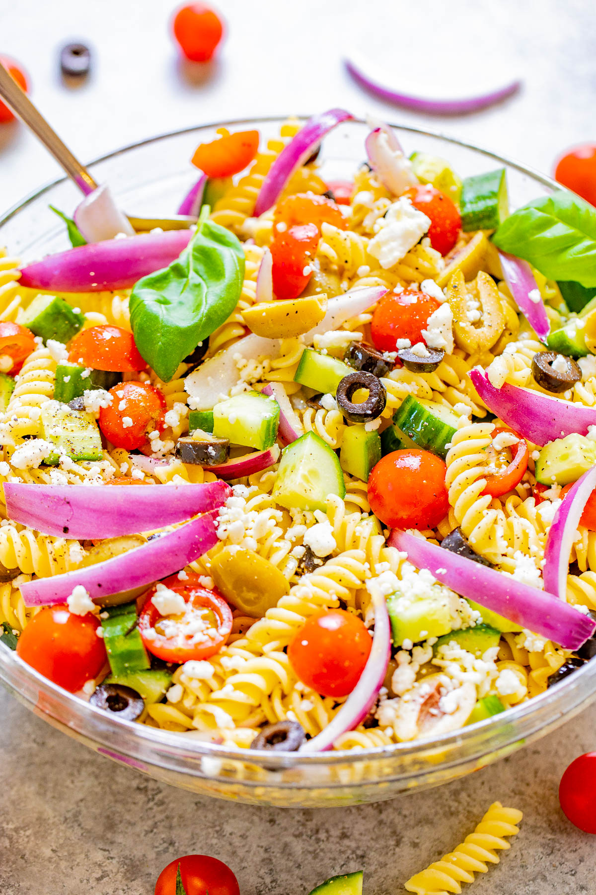 Mediterranean Pasta Salad - Juicy tomatoes and cucumbers, black and green olives, crumbled feta, and tender pasta are tossed in a homemade balsamic vinaigrette! An EASY pasta salad recipe with Mediterranean-inspired ingredients that's ready in under 30 minutes! It makes a big batch and is perfect for potlucks, picnics, or planned leftovers. 