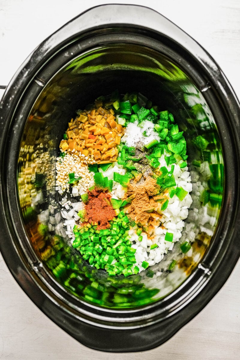 Veggies and spices in a slow cooker.