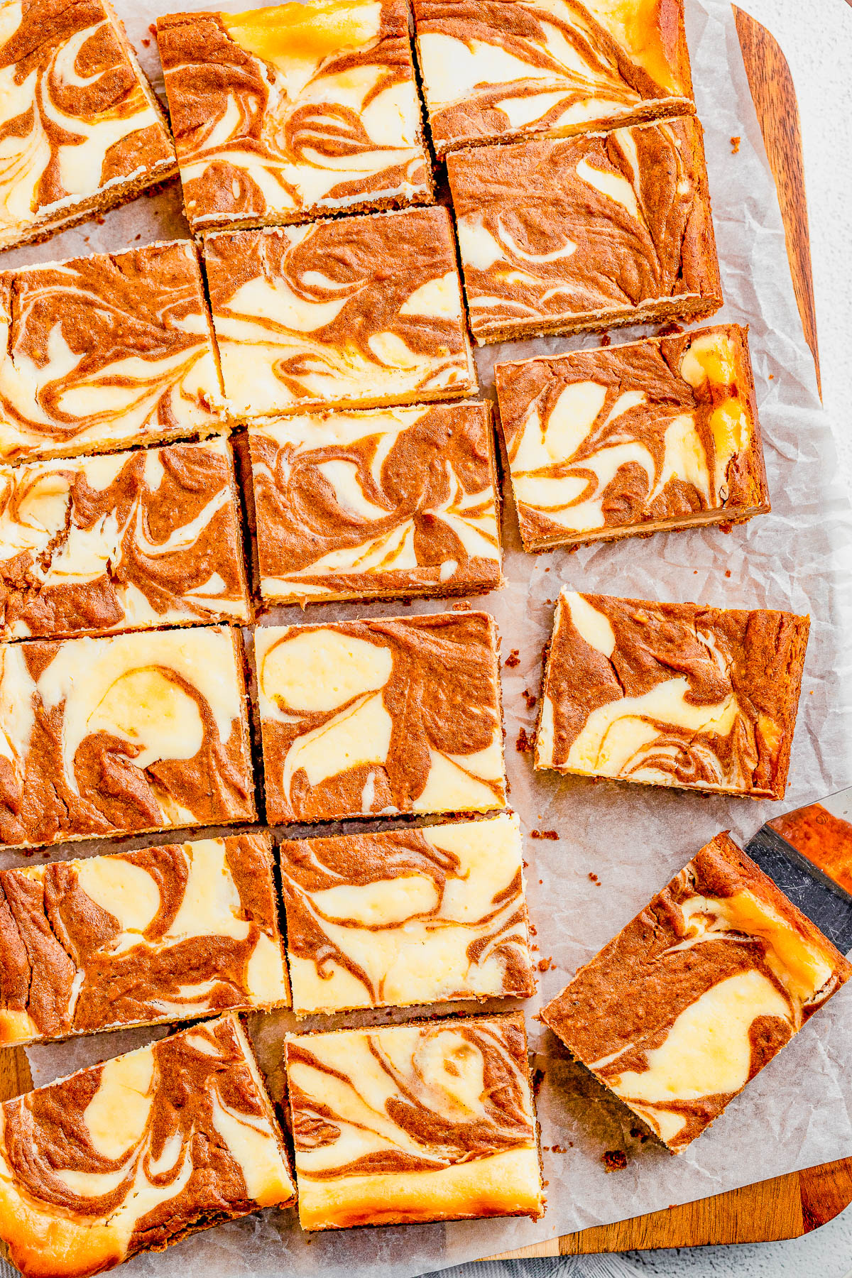 Pumpkin Cheesecake Bars — Classic cheesecake bars get an autumnal makeover in this recipe! A spiced pumpkin mixture is swirled into creamy cheesecake batter before being baked. Sweet, pumpkin spiced, CREAMY bars with a graham cracker crust for fabulous texture! PERFECT for fall gatherings or Thanksgiving! 