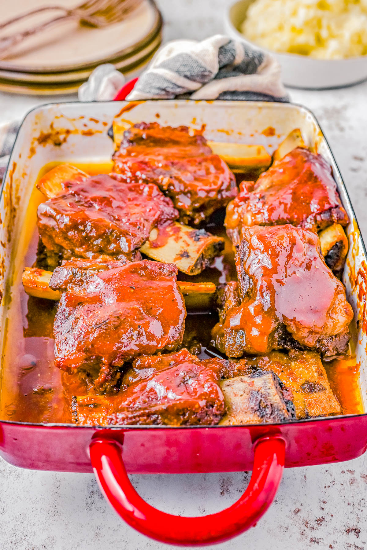 Baked Barbecue Beef Short Ribs - Tender, fall-off-the-bone meat smothered in a homemade BBQ-based sauce that's bursting with sweet, tangy, and smoky flavors! Impress your family and friends with this EASY comfort food recipe that’s perfect for meat lovers and barbecue enthusiasts alike!
