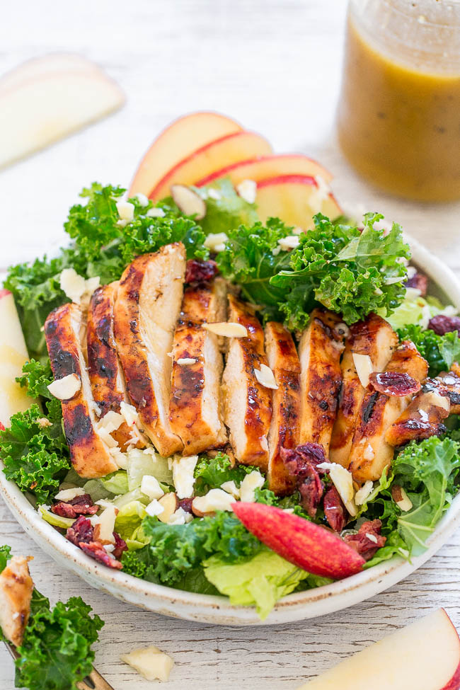 overhead view of grilled chicken salad with a jar of dressing in the background