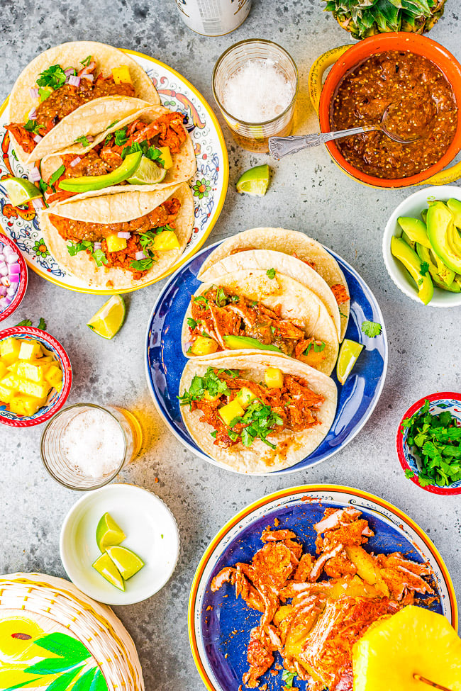 Tacos Al Pastor - Learn to make this staple Mexican recipe that includes thinly sliced pieces of pork marinated in a tangy, sweet pineapple sauce AT HOME!  Juicy, flavorful, tender pork served in tortillas with onions, cilantro, lime juice, and salsa! You'll want every night to be taco night! 