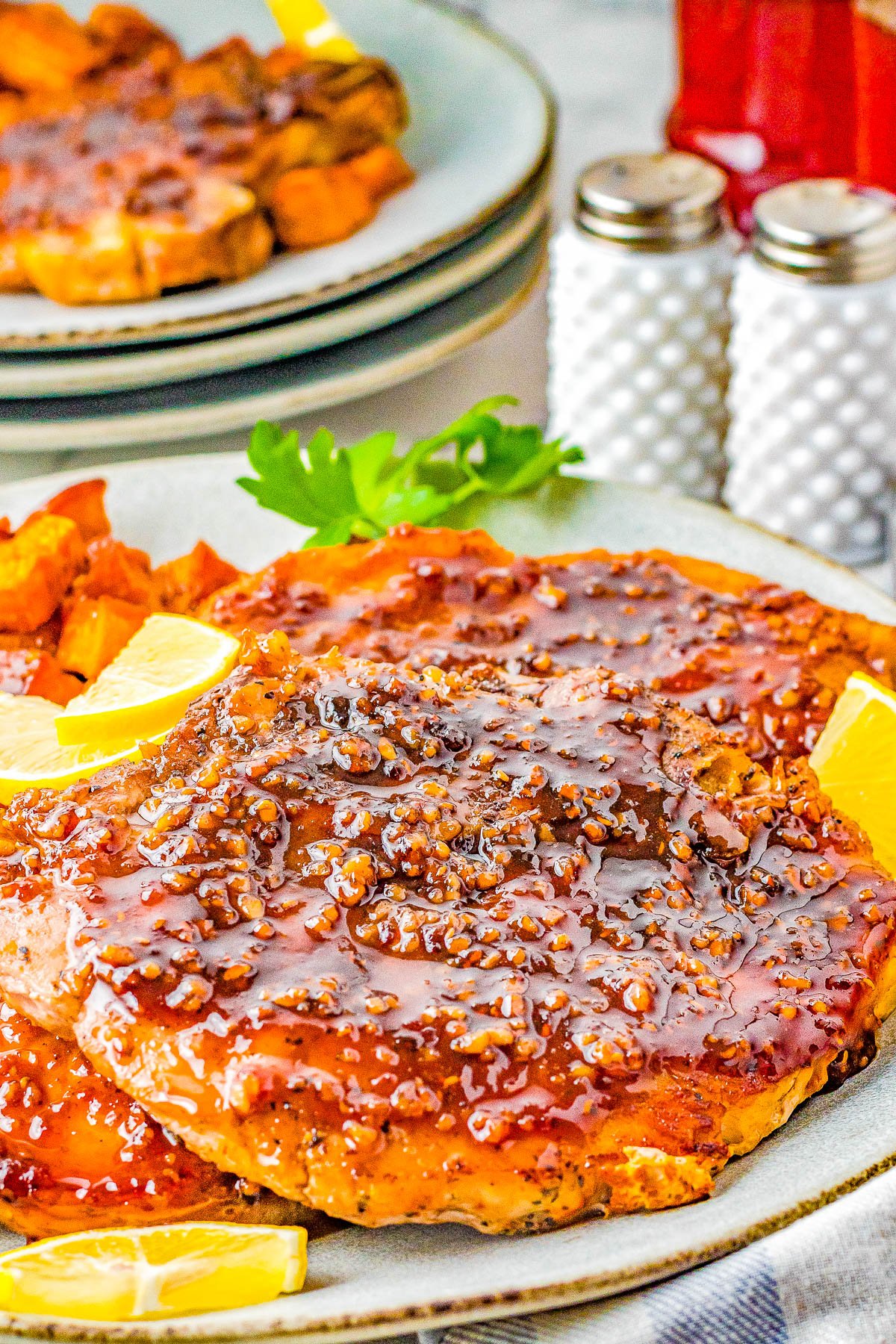 Maple Glazed Pork Chops and Sweet Potatoes - The PERFECT fall-inspired dinner with juicy pork chops that are smothered with the most mouthwatering maple bourbon glaze and cinnamon-and-spiced roasted sweet potatoes on the side! This stunning comfort food recipe is great for family dinners and busy weeknights because it's EASY to make!  