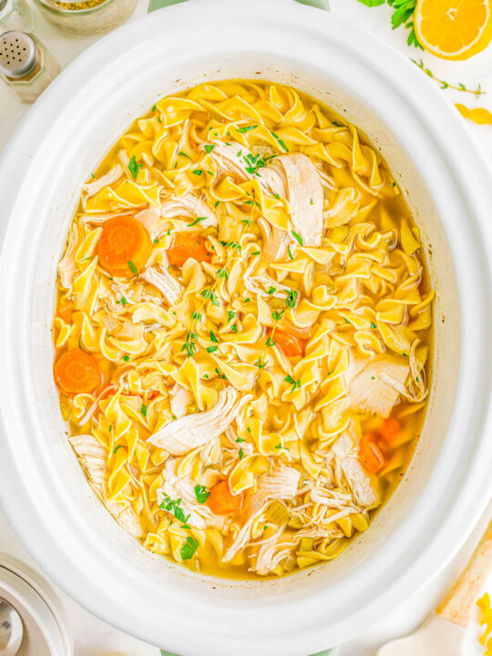 Slow Cooker Chicken Noodle Soup - Classic and comforting chicken noodle soup with loads of juicy chicken, tender noodles, carrots, celery, and seasoned to perfection so that it tastes just like grandma used to make it! But this recipe is made with EASE and convenience in mind by using your Crock-Pot. Just add the ingredients, set it and forget it, and your soup will taste AMAZING!