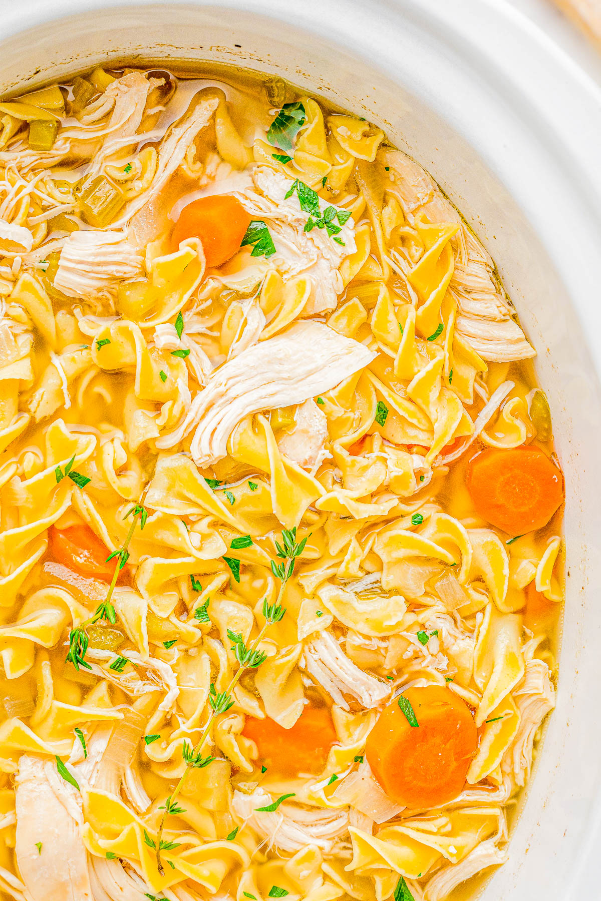 Slow Cooker Chicken Noodle Soup - Classic and comforting chicken noodle soup with loads of juicy chicken, tender noodles, carrots, celery, and seasoned to perfection so that it tastes just like grandma used to make it! But this recipe is made with EASE and convenience in mind by using your Crock-Pot. Just add the ingredients, set it and forget it, and your soup will taste AMAZING!