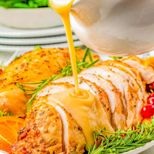 Slow Cooker Turkey Breast on a plate with gravy being poured on top.