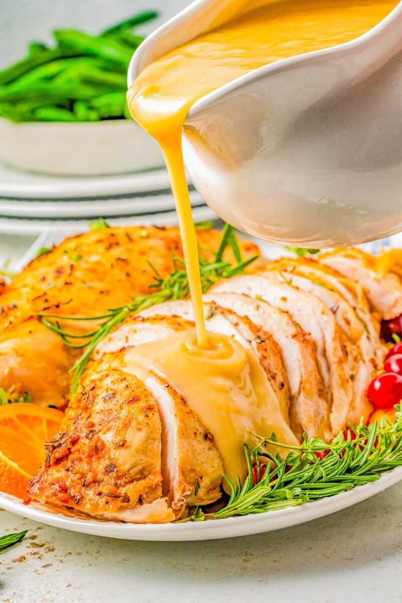 Slow Cooker Turkey Breast on a plate with gravy being poured on top.