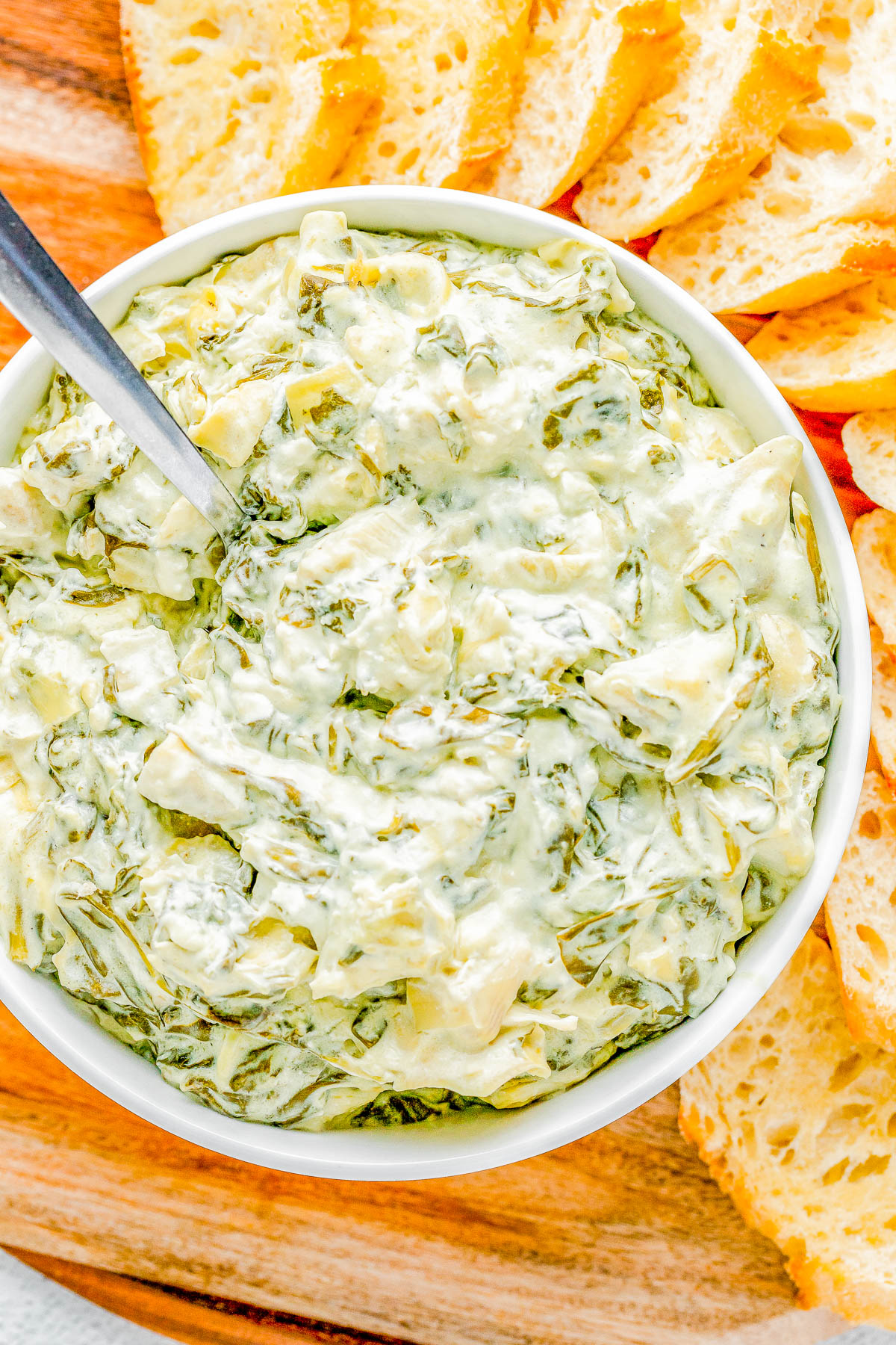 Crockpot Spinach Artichoke Dip - Creamy, cheesy, and best of all SO EASY! Add the spinach, artichokes, mozzarella, and Parmesan to your slow cooker and let it do all the work! All you have to do is stir, serve, and watch everyone devour the dip! It's better than any restaurant version and perfect for holiday entertaining, Christmas and New Year's parties, Super Bowl, or anytime you need the BEST spinach and artichoke dip!