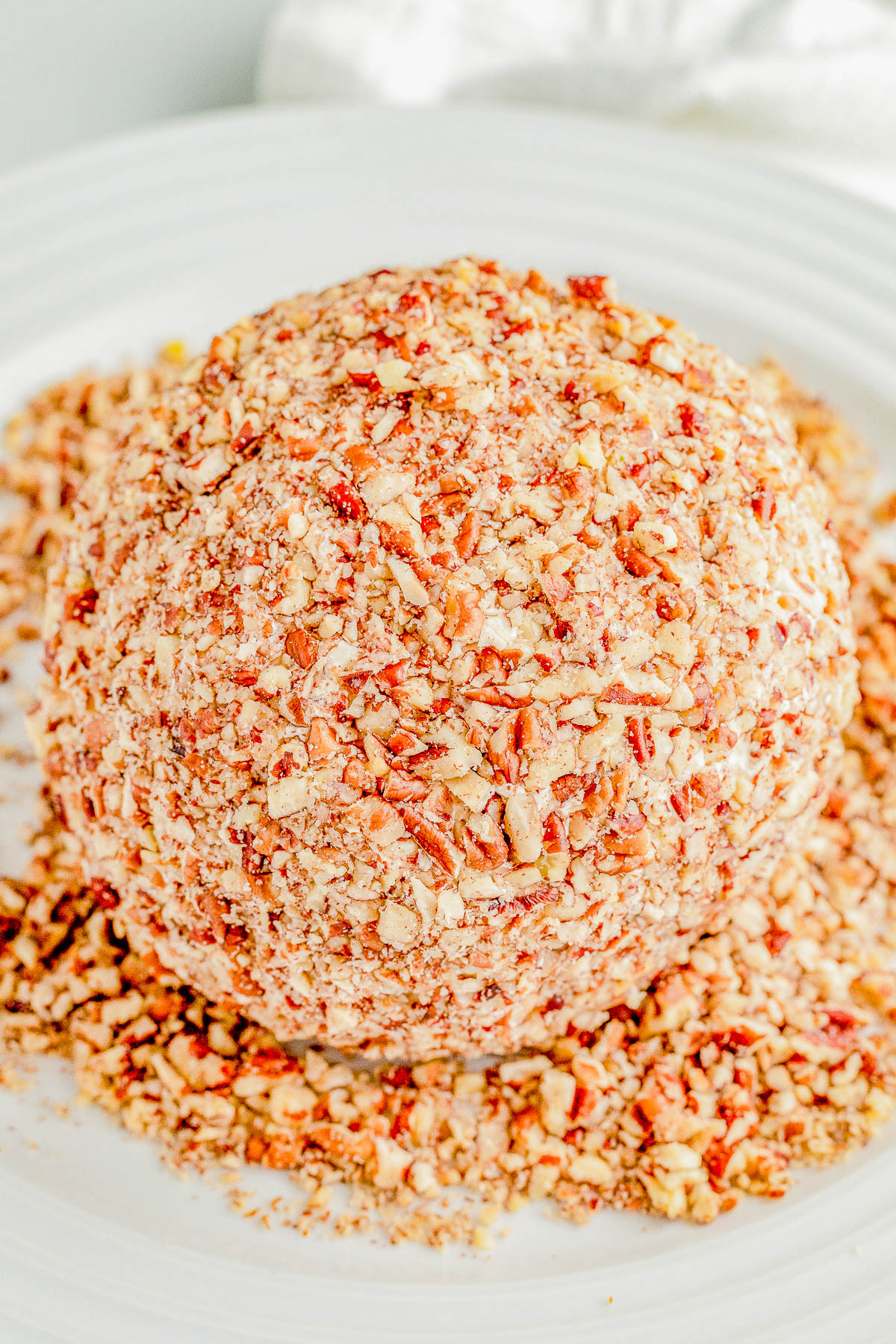Pineapple Cheese Ball - An EASY holiday appetizer recipe that's a party favorite! Made with tangy cream cheese, juicy pineapple, green bell peppers, green onions, and plenty of nuts for lovely crunch and texture! It's a super simple dump-and-stir recipe with no baking, no cooking, no mixer, and no fuss! Serve this at Christmas parties, New Year's Eve, Super Bowl, and any time you need a guaranteed winner!