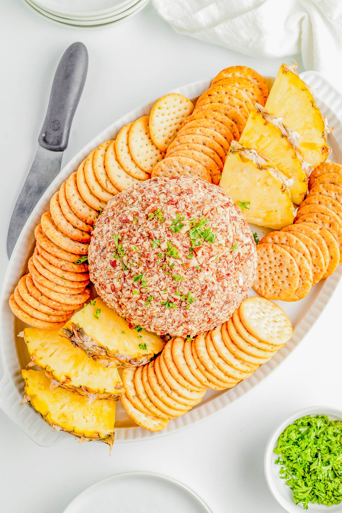 Pineapple Cheese Ball - An EASY holiday appetizer recipe that's a party favorite! Made with tangy cream cheese, juicy pineapple, green bell peppers, green onions, and plenty of nuts for lovely crunch and texture! It's a super simple dump-and-stir recipe with no baking, no cooking, no mixer, and no fuss! Serve this at Christmas parties, New Year's Eve, Super Bowl, and any time you need a guaranteed winner! 