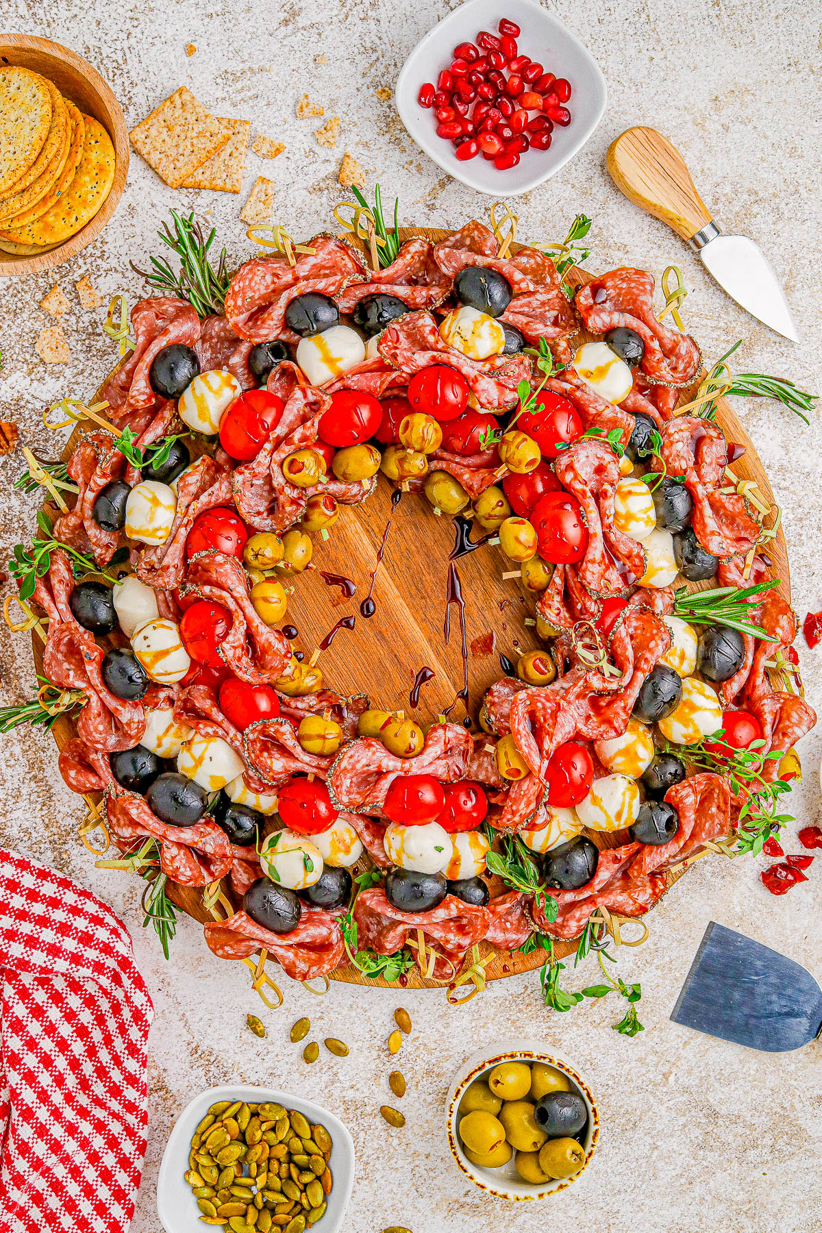 Holiday Antipasto Wreath - A fun and festive Christmas or New Year's Eve appetizer recipe idea that's so FAST and EASY to make! Skewered salami, mozzarella, tomatoes, olives, fresh herbs, and more come together to form the wreath. Mix-and-match the ingredients based on your favorites. You can prep it ahead of your party or event and when your guests see this, I guarantee everyone's eyes will light up!
