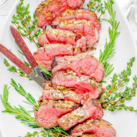 Easy Beef Tenderloin Roast with Garlic Herb Butter sliced on a platter.