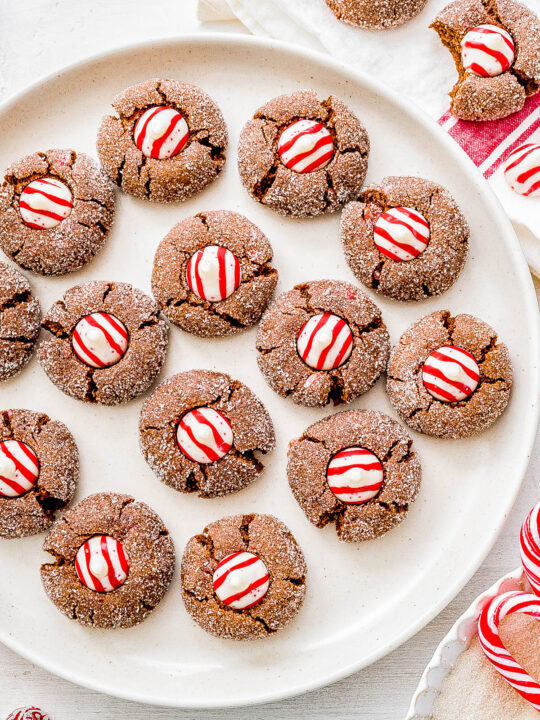 Chocolate Peppermint Kiss Cookies — Chocolate cookie dough is studded with crushed candy cane pieces and flavored with peppermint extract for incredible chocolate-peppermint flavor! These cookies are soft and chewy on the inside and slightly crisp on the outside thanks to the sugar coating. These are PERFECT peppermint Christmas cookies and everyone adores them at holiday parties and cookie exchanges! FAST and EASY too - no dough chilling required!