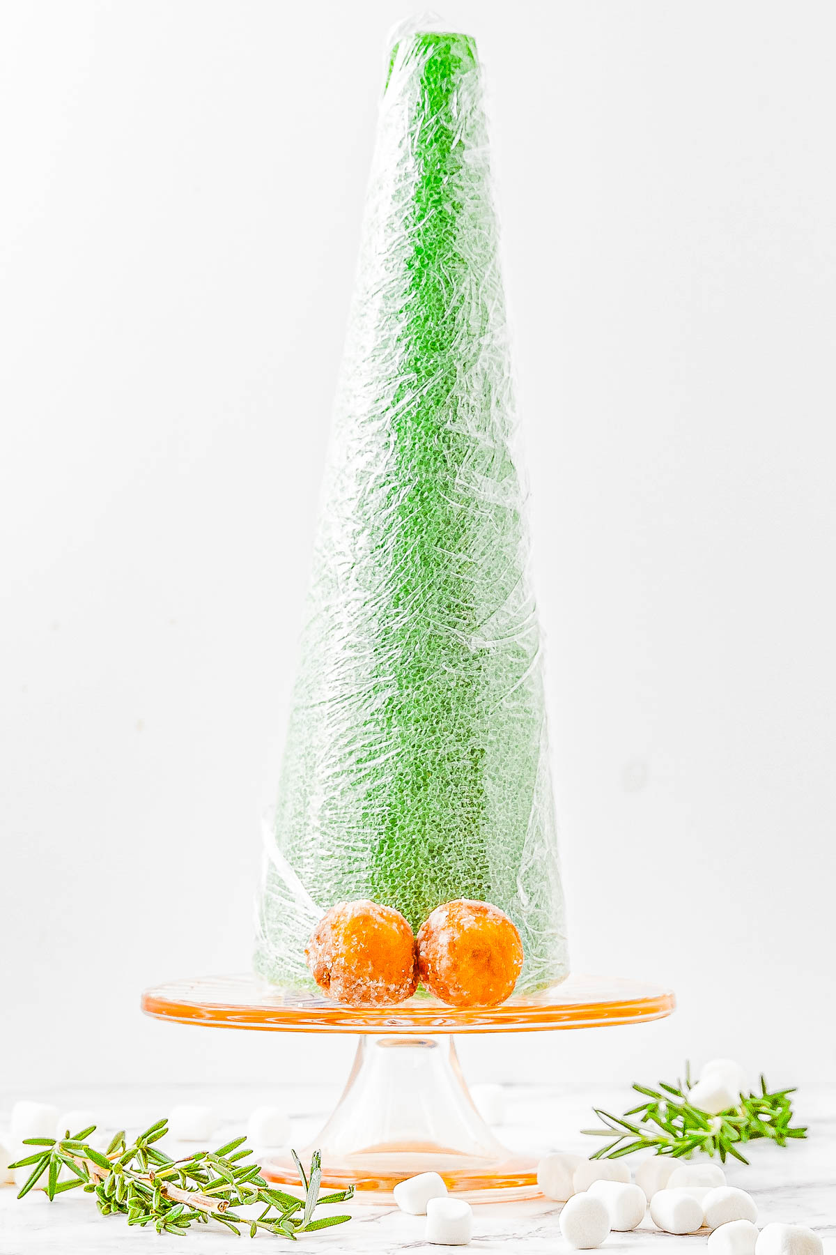 Donut Hole Christmas Tree — Looking for a QUICK and EASY, yet FESTIVE centerpiece for your holiday dessert table or brunch spread? Try making a Christmas tree out of donut holes! All you need is a styrofoam cone from the craft store and some store-bought donut holes. Decorate your tree however you want, then let guests help themselves!   