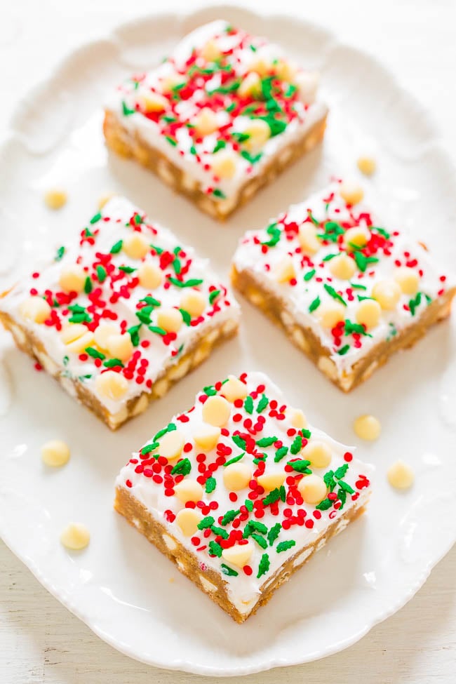 four frosted white chocolate blondies on a white platter 