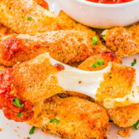 Air Fryer Mozzarella Sticks with Marinara Dipping Sauce - Soft, gooey, melted mozzarella cheese inside a crispy and lightly crunchy golden brown exterior is what you have with this quick and EASY mozzarella cheese sticks recipe! Pair them with my herb-flavored marinara sauce for dipping! The perfect appetizer for your next game day party, casual entertaining event, or just a tv night at home because everyone LOVES these! 