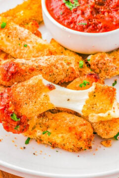 Air Fryer Mozzarella Sticks with Marinara Dipping Sauce - Soft, gooey, melted mozzarella cheese inside a crispy and lightly crunchy golden brown exterior is what you have with this quick and EASY mozzarella cheese sticks recipe! Pair them with my herb-flavored marinara sauce for dipping! The perfect appetizer for your next game day party, casual entertaining event, or just a tv night at home because everyone LOVES these! 