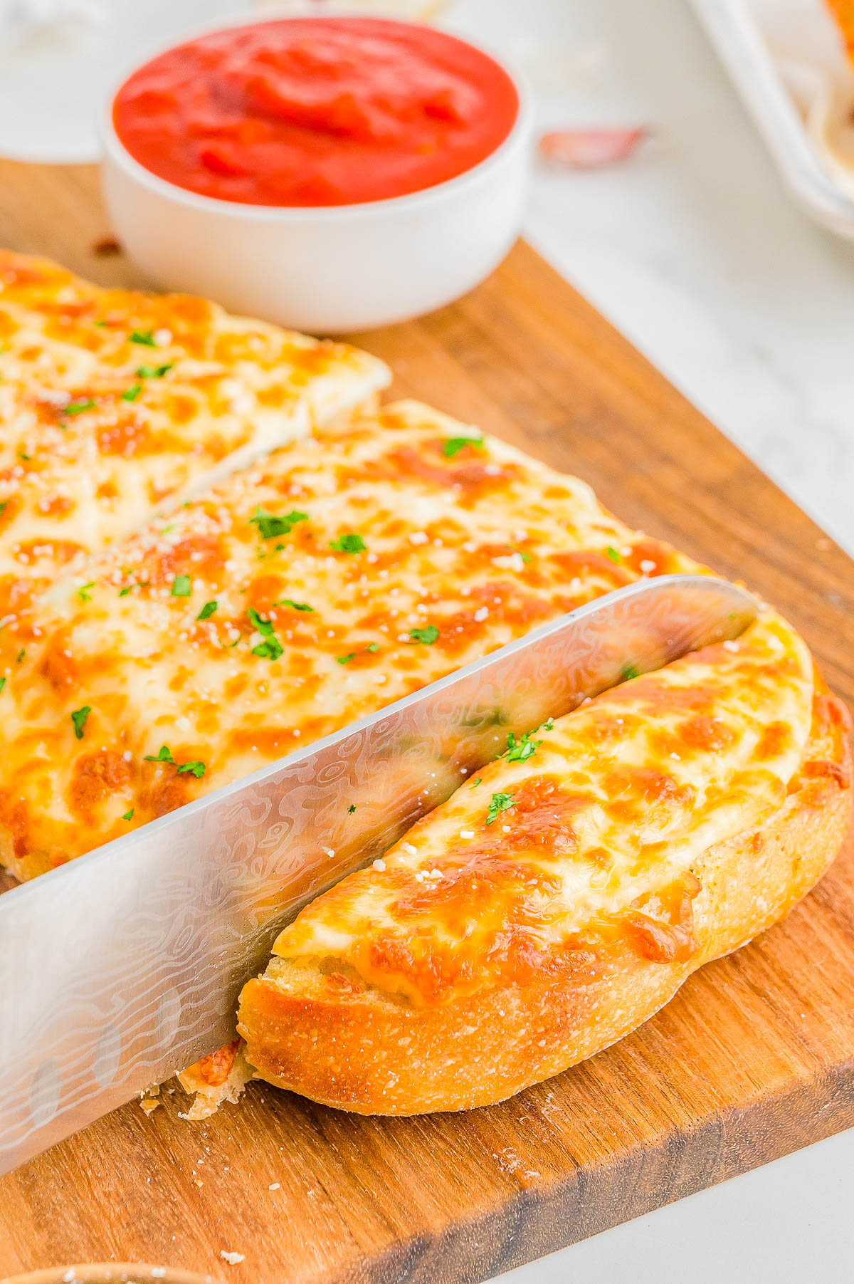 Easy Cheesy Garlic Bread - French bread that's been brushed with melted garlic butter and Italian seasoning, then topped with mounds of mozzarella and Parmesan cheeses, and baked to perfection is what this EASY appetizer, snack, or side is all about! Garlic bread with cheese is a family favorite that no one can resist and ready in just 15 minutes!