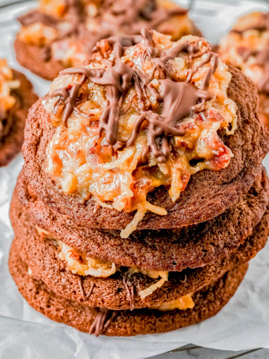 German Chocolate Cookies — An EASY recipe for soft, chewy, fudgy chocolate cookies that are topped with a rich and creamy pecan coconut frosting! If you love German chocolate cake but don’t want to deal with layering and frosting an entire cake, these cookies are PERFECT! Great for holiday cookie platters, Valentine's Day, or 'just because'! They're a Crumbl Cookies copycat and I promise that this homemade version is BETTER!