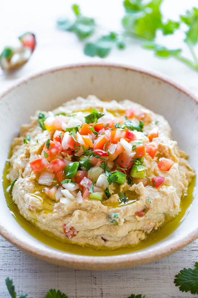Easy Taco Hummus — Jazz up classic hummus with pico de gallo, cilantro, and you won't be able to stop digging into it with tortilla chips!! Easy, healthy, ready in 5 minutes, and a perfect snack that everyone loves!